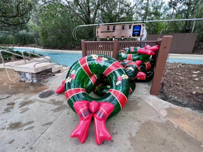 A green and red circular pool float is designed to look like a Christmas wreath and bow for the holidays at Disney's Blizzard Beach water park.