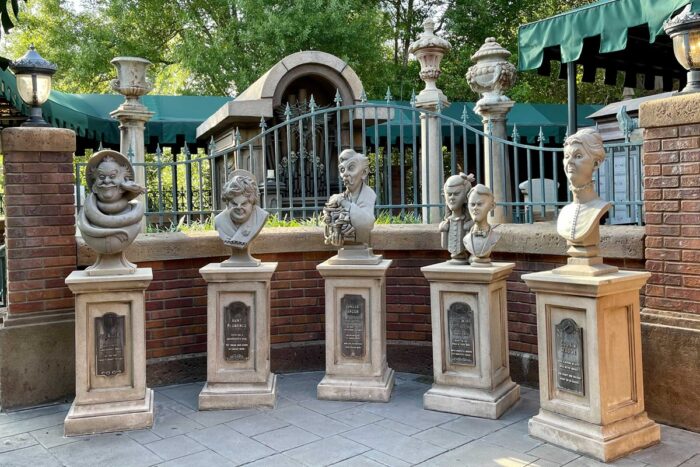 five busts on pedestals are organized in a semi-circle in the queue of the Haunted Mansion