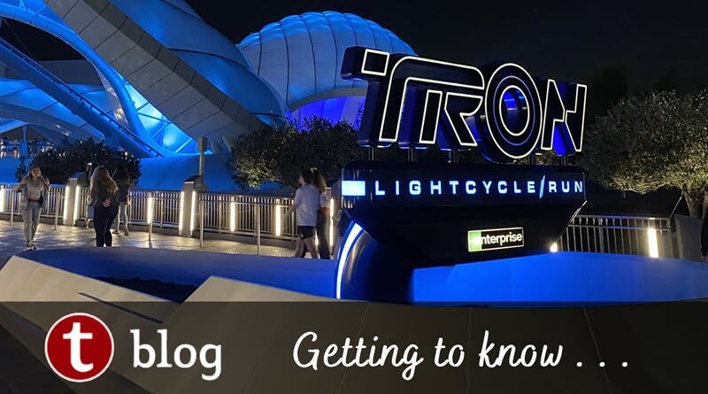 Five things to know about TRON cover image showing the entrance and canopy at night with blue lighting.